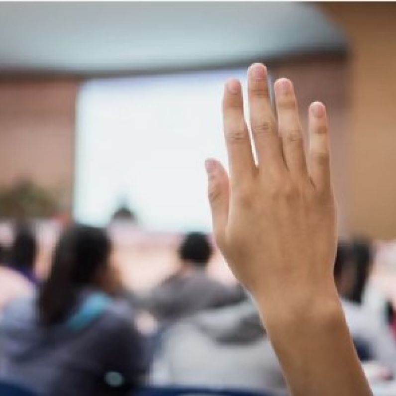 Raised hand in a conference room